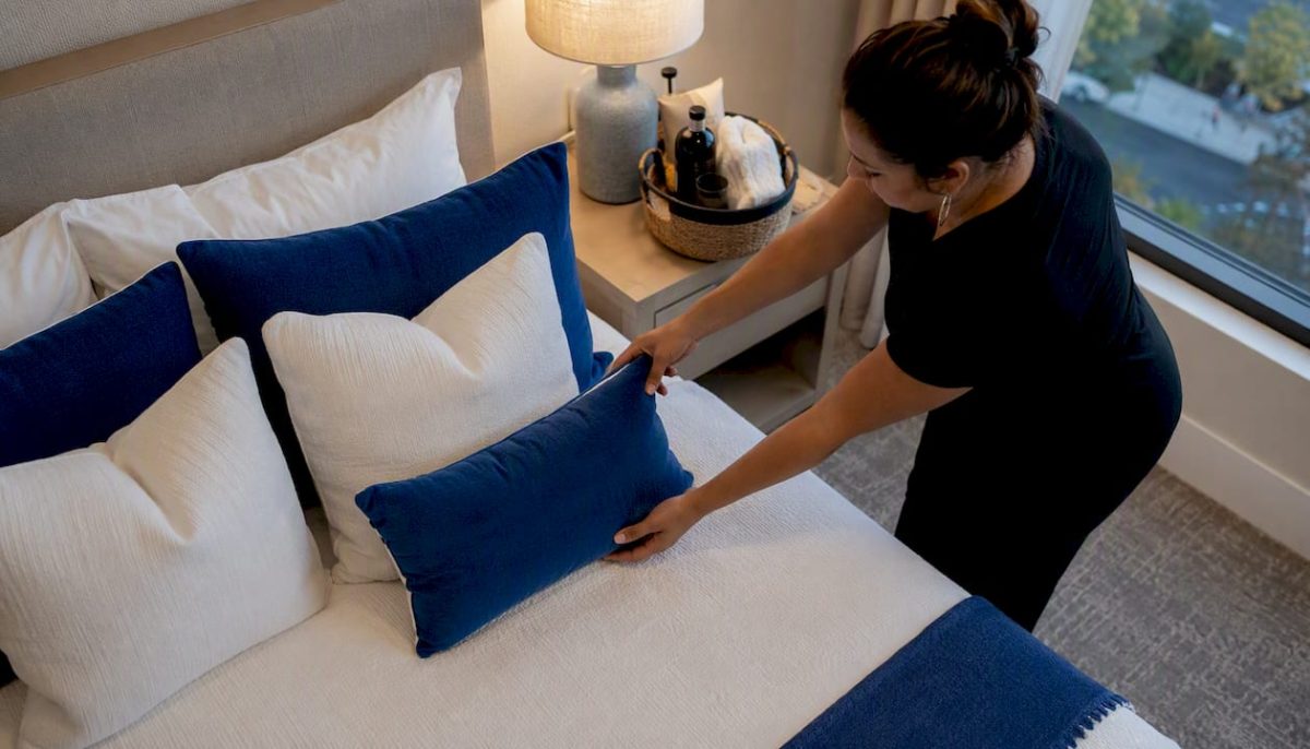 Adding pillows to luxury rental bed for guest preferences