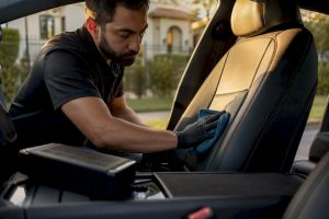 Hands placing odor neutralizer inside car