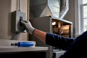 Technician inspecting HVAC system safely